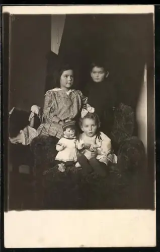 Foto-AK Knabe und Mädchen mit Puppen auf einem Sessel