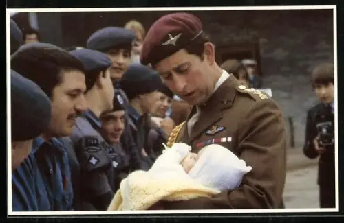 AK Prince Charles in uniform holding another baby