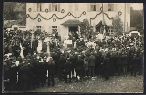 Foto-AK Mondsee, Veranstaltung vor einem geschmückten Gebäude, Fahnen