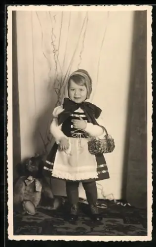 Foto-AK Kleines Mädchen im Dirndl neben seinem Teddy