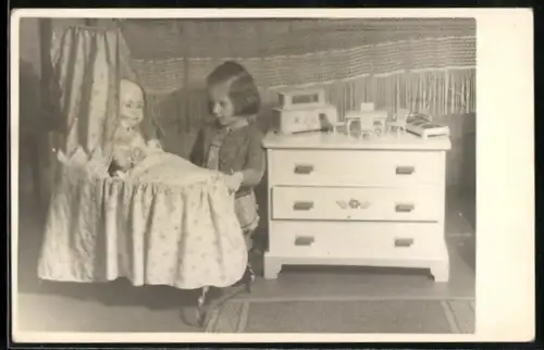 Foto-AK Kleines Mädchen mit Puppen in der Wiege