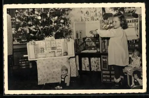 Foto-AK Kleines Mädchen mit Puppen am Weihnachtsbaum