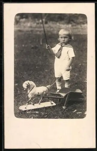 Foto-AK Kleiner Junge im Matrosenhemd mit Spielzeugpferd