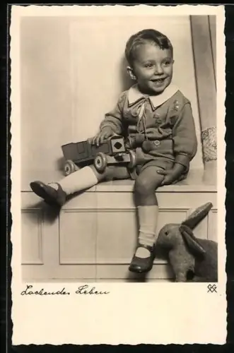 AK Kleiner Junge mit Spielzeugauto und Plüschhasen