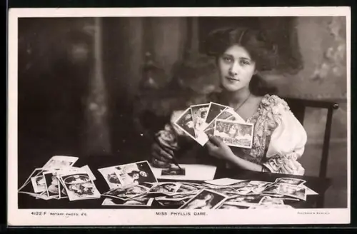 AK Schauspielerin Phillys Dare hält Postkarten mit ihrem Bildnis in den Händen