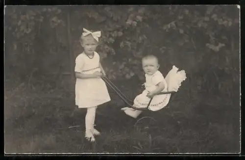 Foto-AK Mädchen schiebt einen Kinderwagen mit Kleinkind