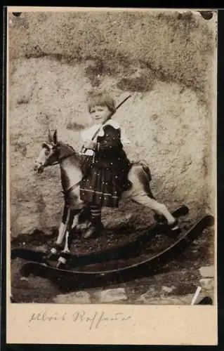 Foto-AK Mädchen auf einem Schaukelpferd mit geschultertem Säbel