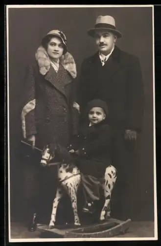 Foto-AK Elegantes Paar mit Kind auf einem Schaukelpferd