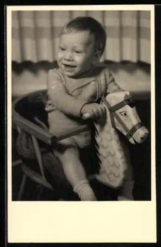 Foto-AK Fröhliches Kind auf einem Schaukelpferd