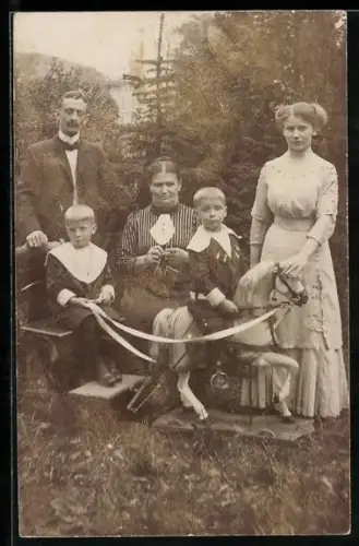 Foto-AK Familie mit Kindern auf einem Schaukelpferd
