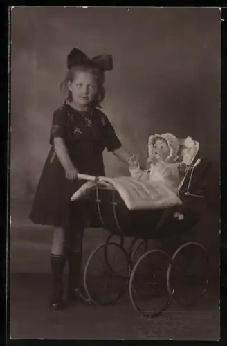 Foto-AK Mädchen mit einem Kinderwagen und einer Puppe darin