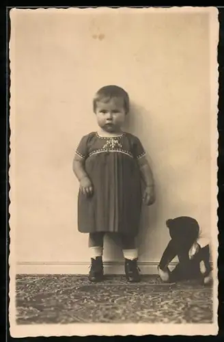 Foto-AK Pausbäckiges Kind steht neben seinem Teddybären