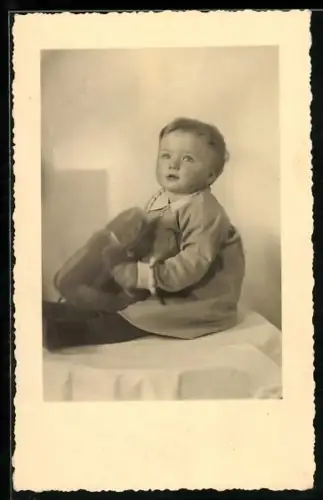 Foto-AK Kleinkind sitzt mit einem Teddy auf einem Tisch