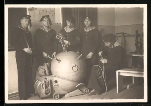 Fotografie Matrosen in Uniform mit einer Seemine zur Schulung