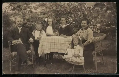 Foto-AK Familie und Mädchen mit Puppe am Gartentisch