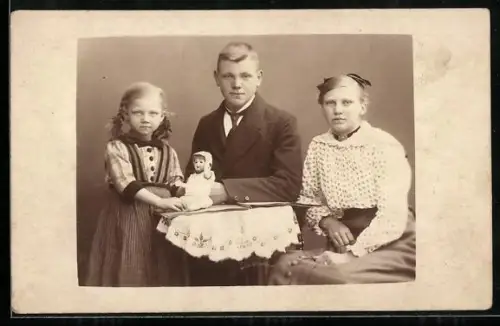 Foto-AK Drei Kinder spielen mit einer Puppe