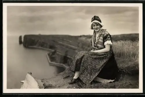 AK Helgoland, Hübsche Helgoländerin auf Felsen sitzend, Fotograf F. Schensky