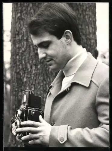 Fotografie junger Mann mit seiner Flexaret Kamera schiesst ein Foto