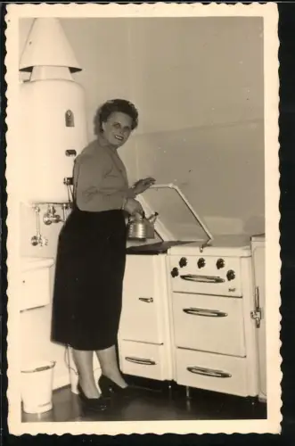 Fotografie Hausfrau am Herd bereitet Wasser zu