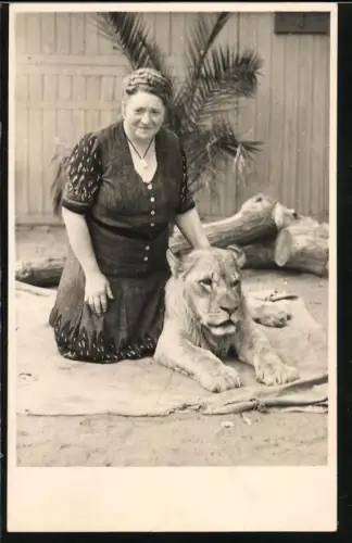 Fotografie Tiertrainerin mit Löwe auf einer Decke