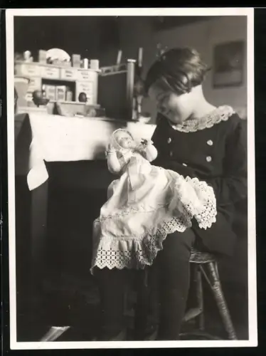 Fotografie Mädchen spielt mit ihrer Puppe, Kaufmannsladen
