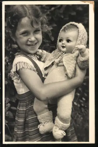 Fotografie kleines Mädchen mit ihrer grosse Puppe im Arm