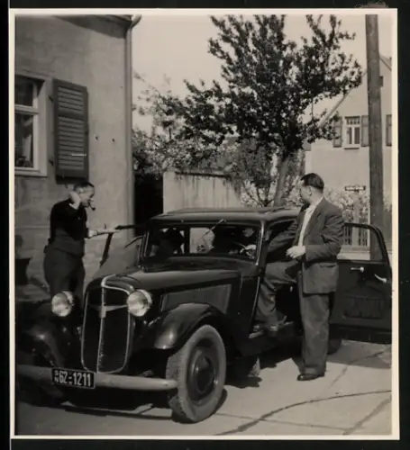 Fotografie Mann steigt in sein Adler Auto ein, Kennzeichen: SN62-1211