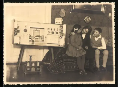 Fotografie Kinder nebst Puppenstube und Spielzeug Herd