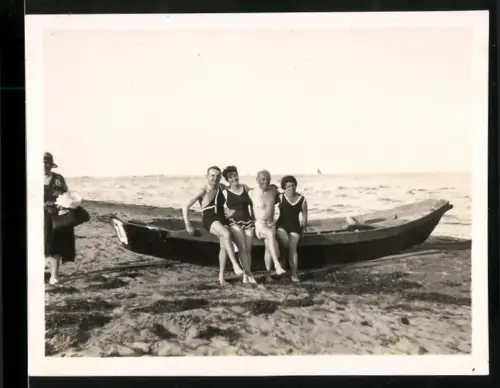 Fotografie Strandgäste in Bademode an einem Ruderboot, 1928