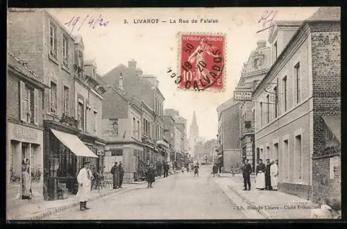 AK Livarot, La Rue de Falaise animée avec passants et commerces