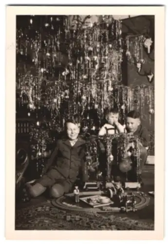 2 Fotografien Weihnachten, junge Knaben mit ihrer Spielzeug Eisenbahn unterm Weihnachtsbaum