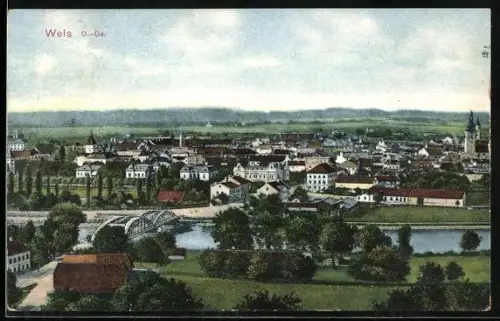 AK Wels /O. Öst., Stadtpanorama mit Fluss und Brücke