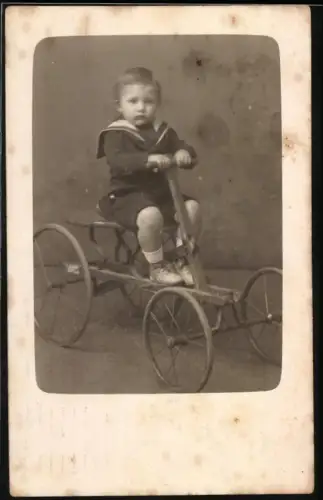 Fotografie junger Knabe auf Draisine mit Handhebel