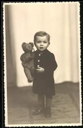Fotografie niedlicher kleiner Knabe zu Weihnachten mit seinem Teddybär im Arm, 1944