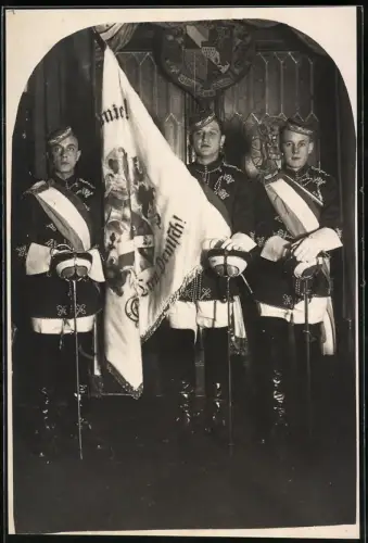 Fotografie drei Studenten im vollen Wichs mit Schläger und Biertönnchen samt Verbindungsfahne