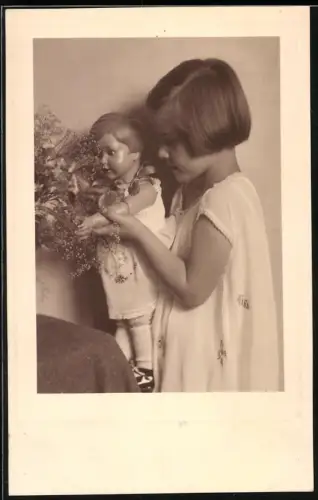 Fotografie Mädchen spielt mit ihrer Zelluloid Puppe, 1930