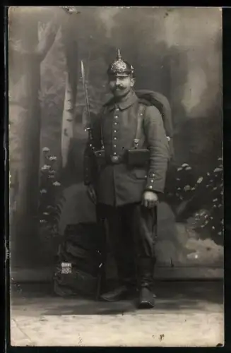 Foto-AK Bayerischer Soldat in Feldgrau Uniform mit Pickelhaube, Koppeltaschen und Gewehr mit aufgepflanztem Bajonett