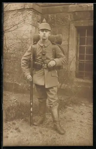 Foto-AK Soldat in Feldgrau Uniform mit Pickelhaube mit Überzug, Signallampe und Gewehr