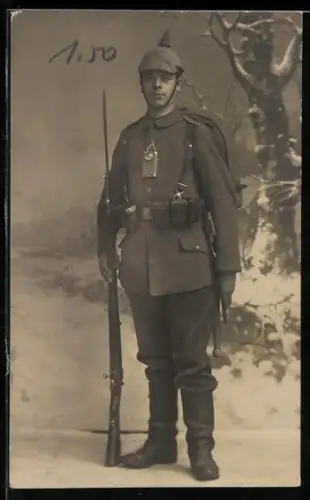 Foto-AK Soldat vom Inf.-Rgt. Nr. 20 in Feldgrau Uniform marschmässig ausgerüstet mit Pickelhaube, Taschenlampe und Gewehr