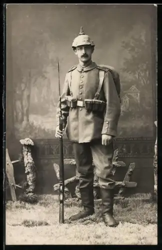 Foto-AK Soldat vom Inf.-Rgt. Nr. 76 in Feldgrau Uniform mit Patronentaschen, Pickelhaube mit Überzug und Gewehr