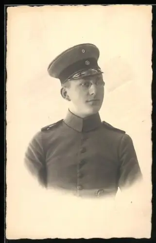 Foto-AK Soldat in Feldgrau Uniform mit Schirmmütze und Verwundetenabzeichen