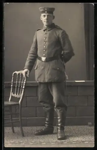 Foto-AK Soldat in Feldgrau Uniform mit Krätzchen und Bajonett