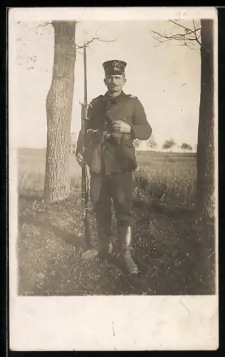 Foto-AK Landwehr-Soldat in Uniform mit Schirmmütze, Patronentaschen und Gewehr mit aufgepflanztem Bajonett