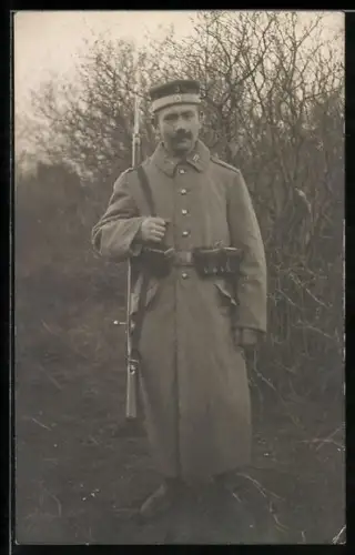 Foto-AK Landwehr-Soldat in Feldgrau Mantel mit Krätzchen, Patronentaschen und Gewehr 98