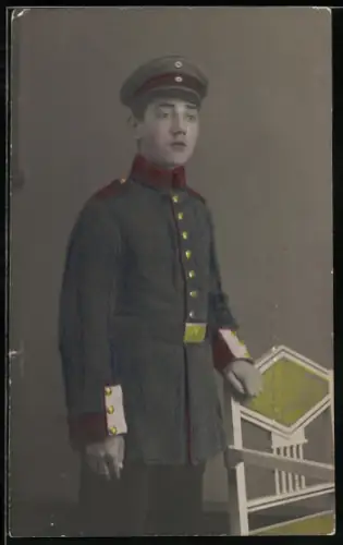 Foto-AK Soldat im Waffenrock mit Schirmmütze, handkoloriertes Foto
