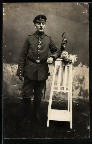 Foto-AK Soldat in Feldgrau Uniform mit Schirmmütze und EK II 1914