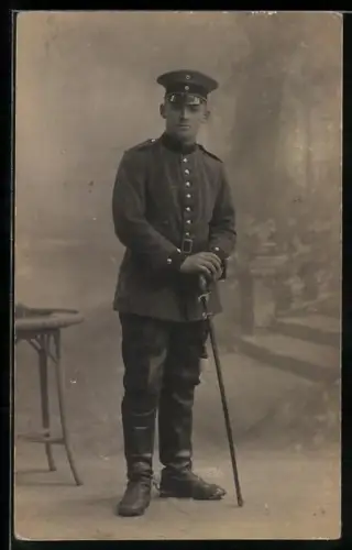 Foto-AK Soldat in Uniform mit Schirmmütze und Säbel