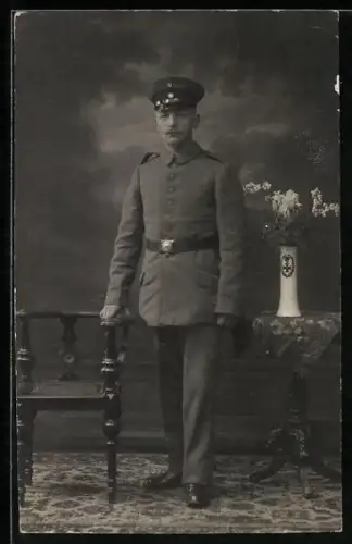Foto-AK Soldat in Feldgrau Uniform mit Schirmmütze