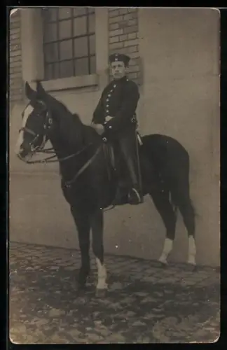 Foto-AK Soldat in Uniform mit Krätzchen und Säbel zu Pferde