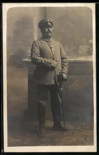 Foto-AK Soldat in Feldgrau Uniform mit Schirmmütze, EK II 1914 und Säbel